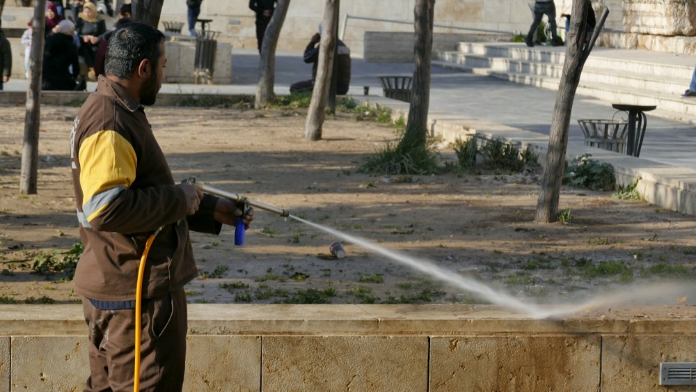 Rinsing a house exterior with a pressure washer
